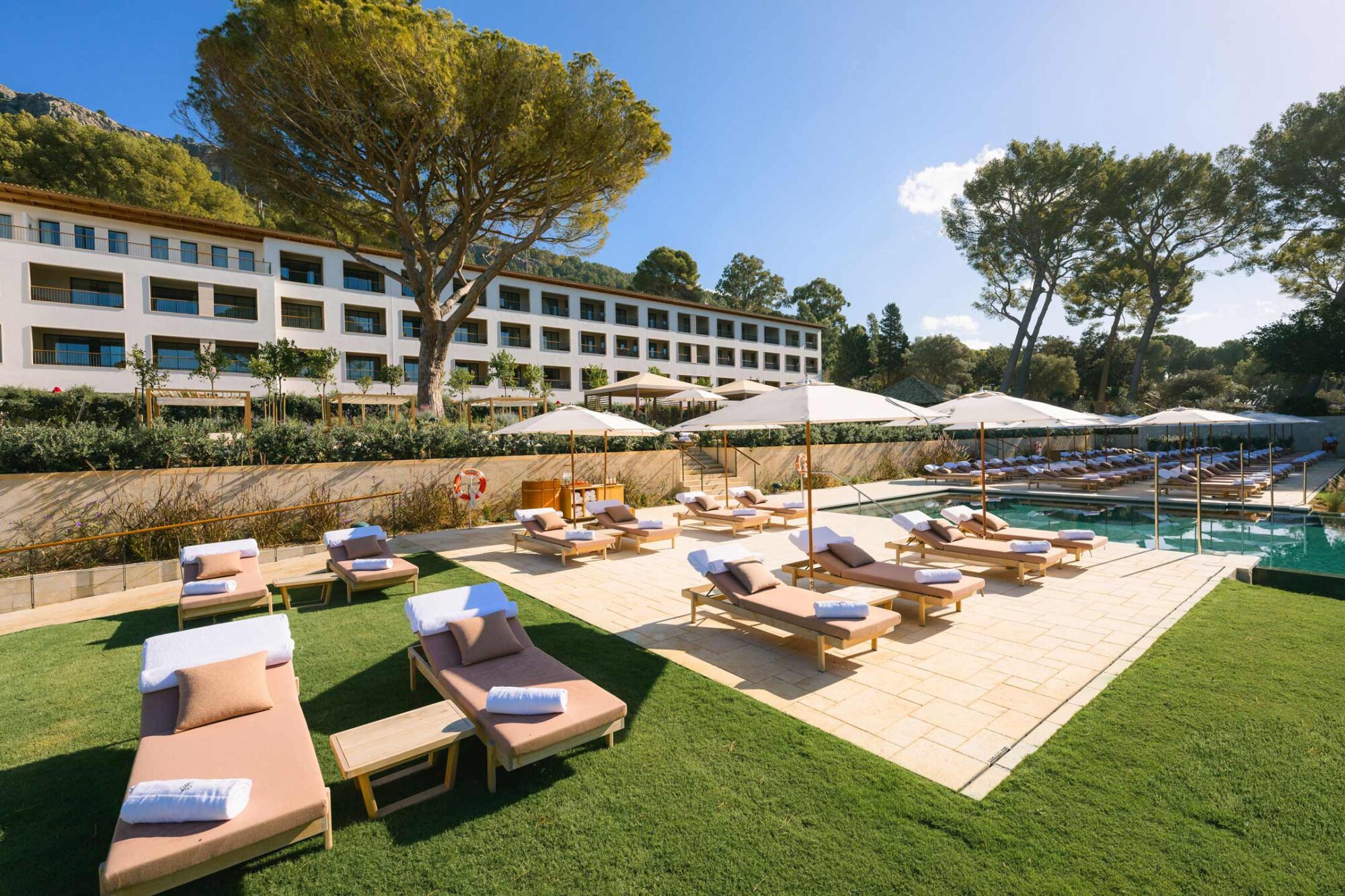 Fachada del Four Seasons Resort Mallorca at Formentor sobre el jardín y la piscina, entre pinos