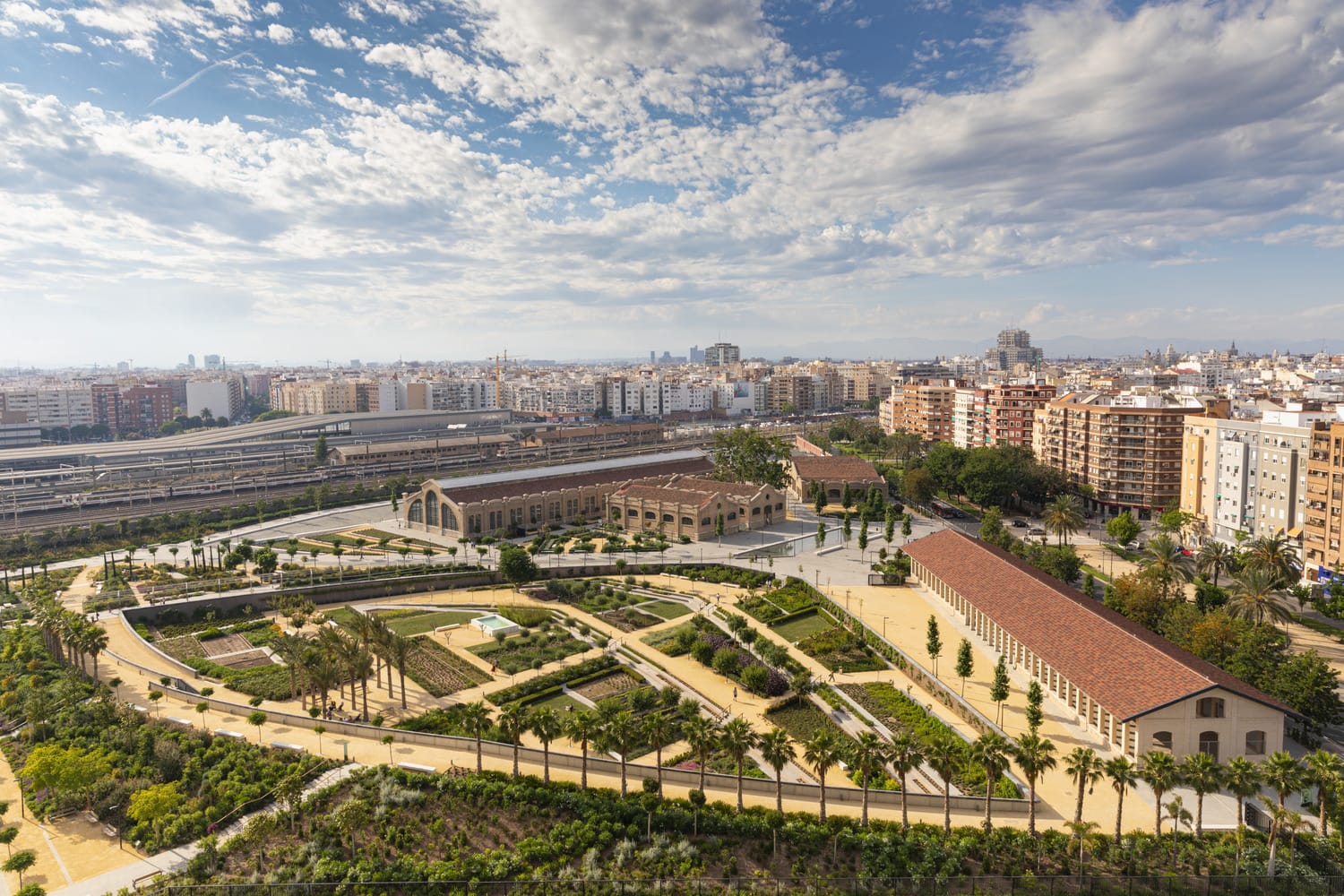 Vista aérea del Parque Central de València con los talleres ferroviarios rehabilitados y la ciudad al fondo